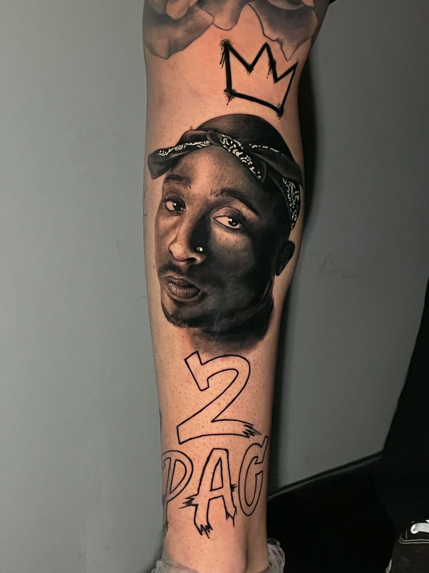 Tatuagem realista em preto e cinza do Tupac por Ricardo