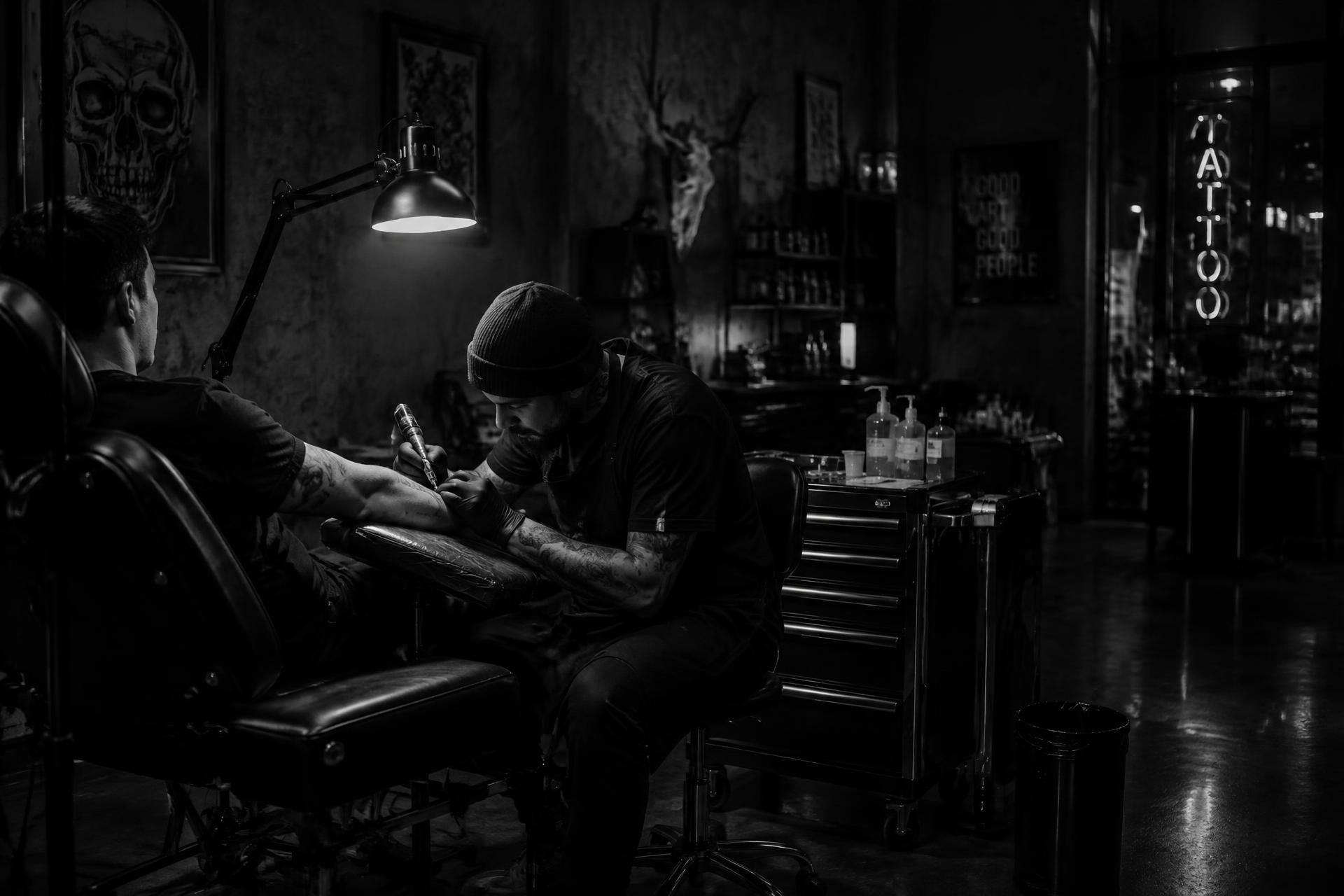 Tatuador trabalhando no estúdio Titans